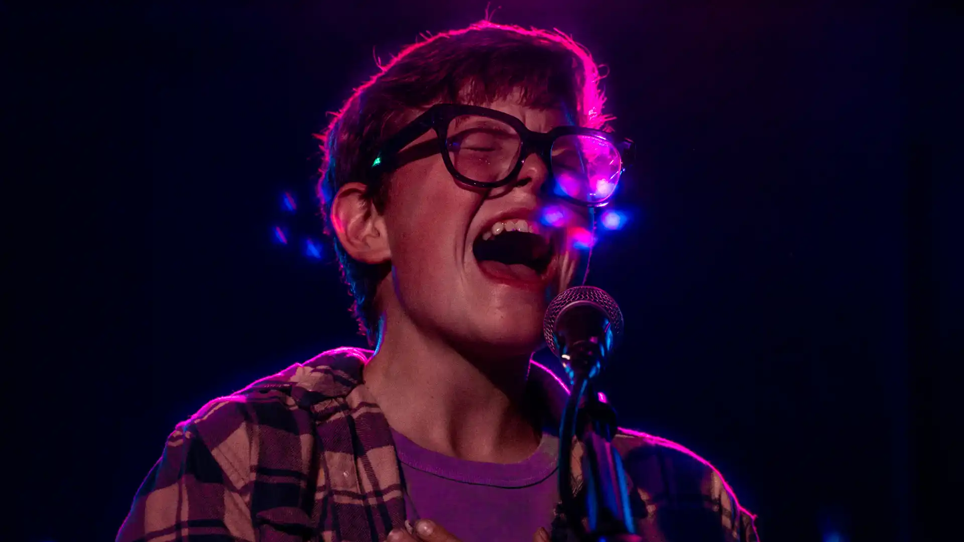 Carson Ferris passionately singing into a microphone.