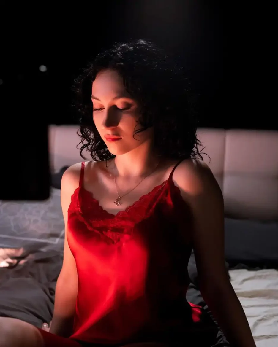 Paloma Amaya posing in a silky red bedroom outfit for a captivating photoshoot.