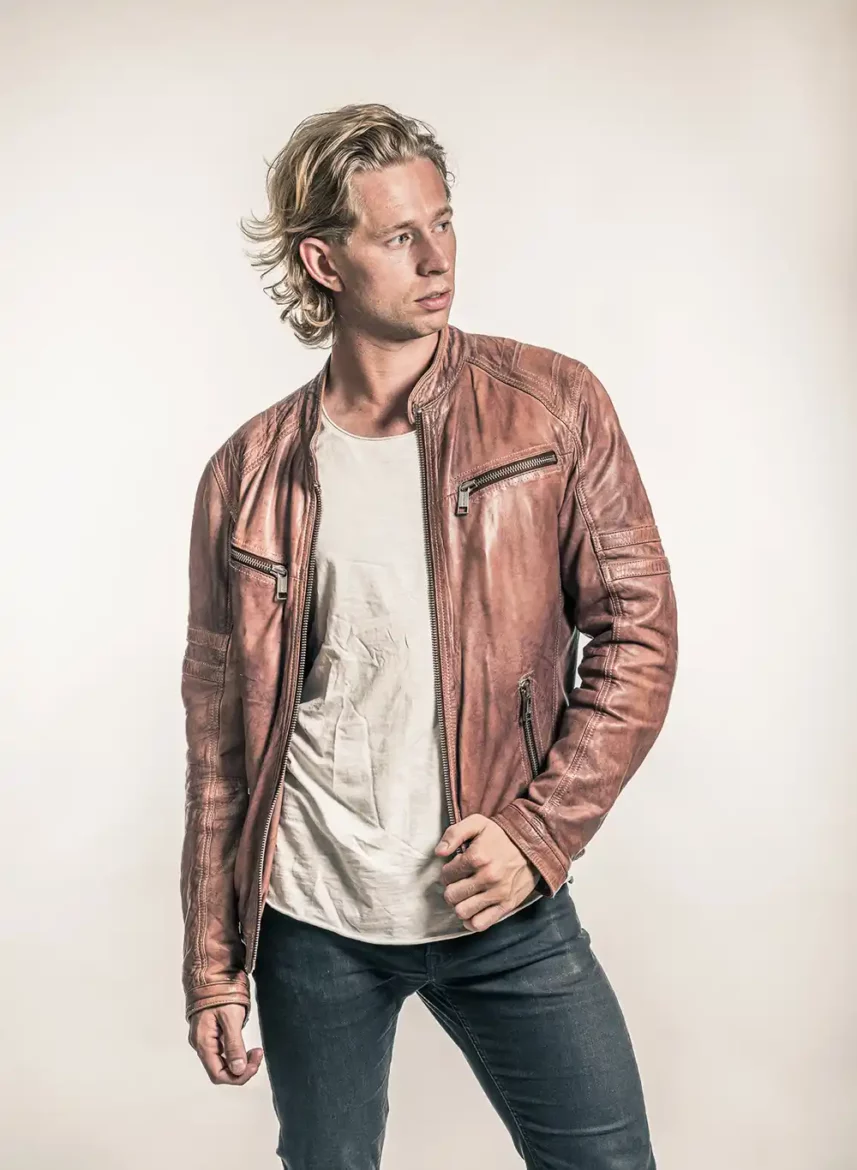 Tom Hamstrom rocking a cool brown leather jacket in a studio photoshoot.