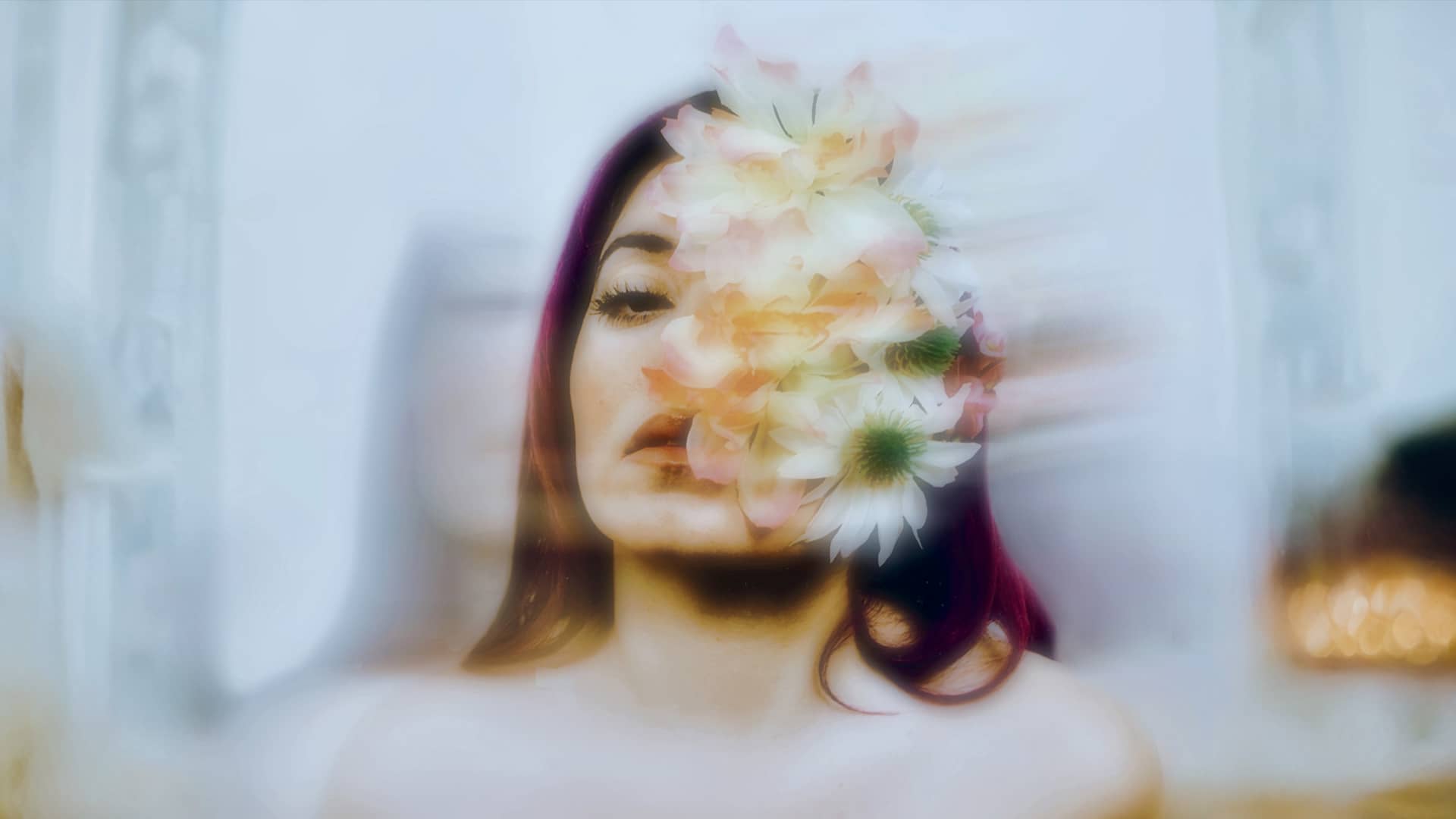Artist with flowers covering her face evoking a dreamy, artistic vibe, hinting at the transformative theme of her music.