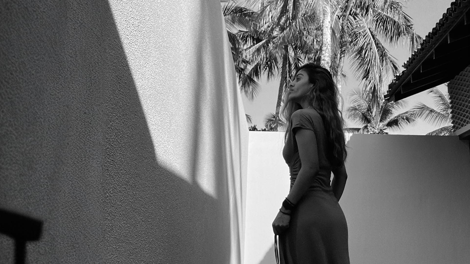 Angie Perera pondering in palm shadows