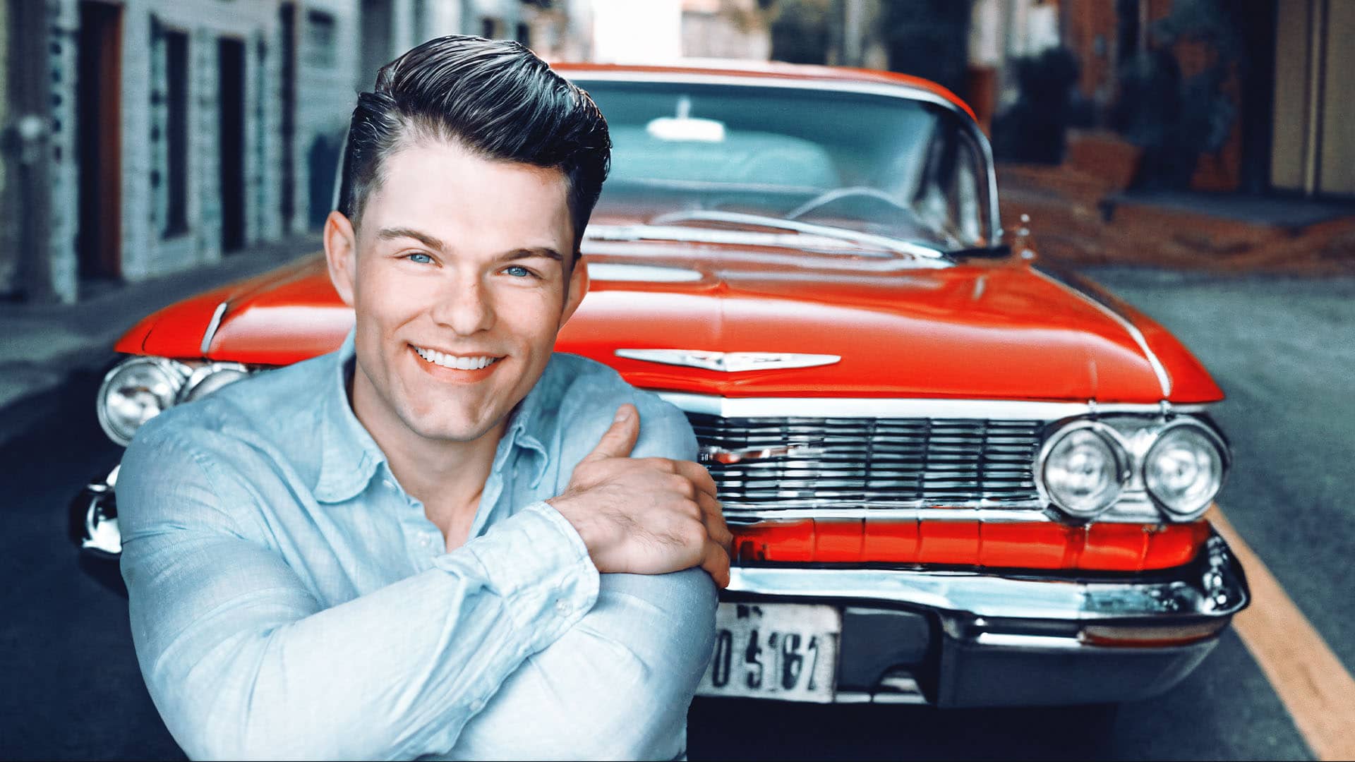 Nick Pritchard leaning on a classic red car, representing his single