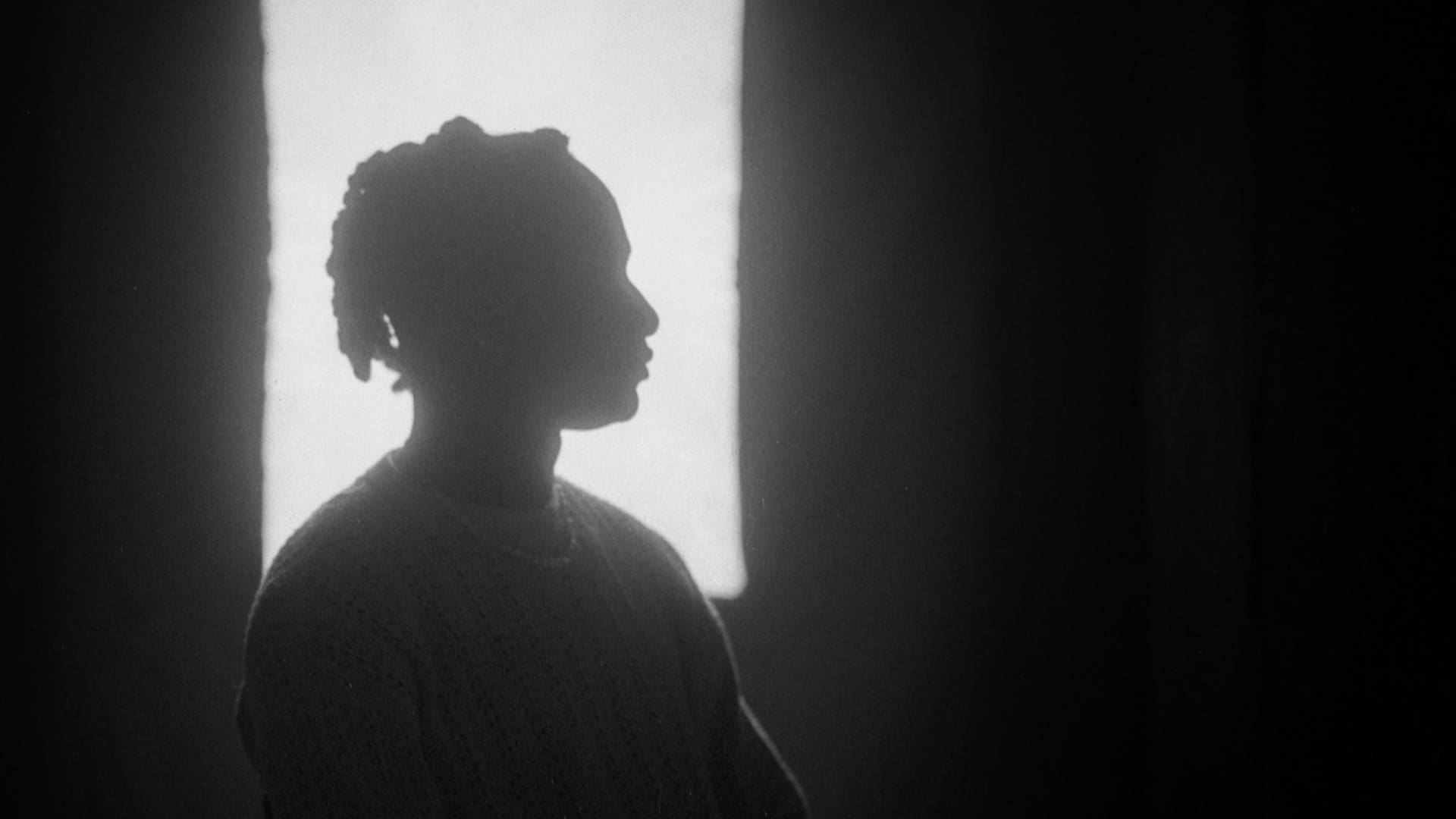 Silhouette of a person in profile against a window light.